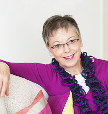 Frau Dr. Krause sitzt entspannt auf dem Sofa und lächelt freundlich